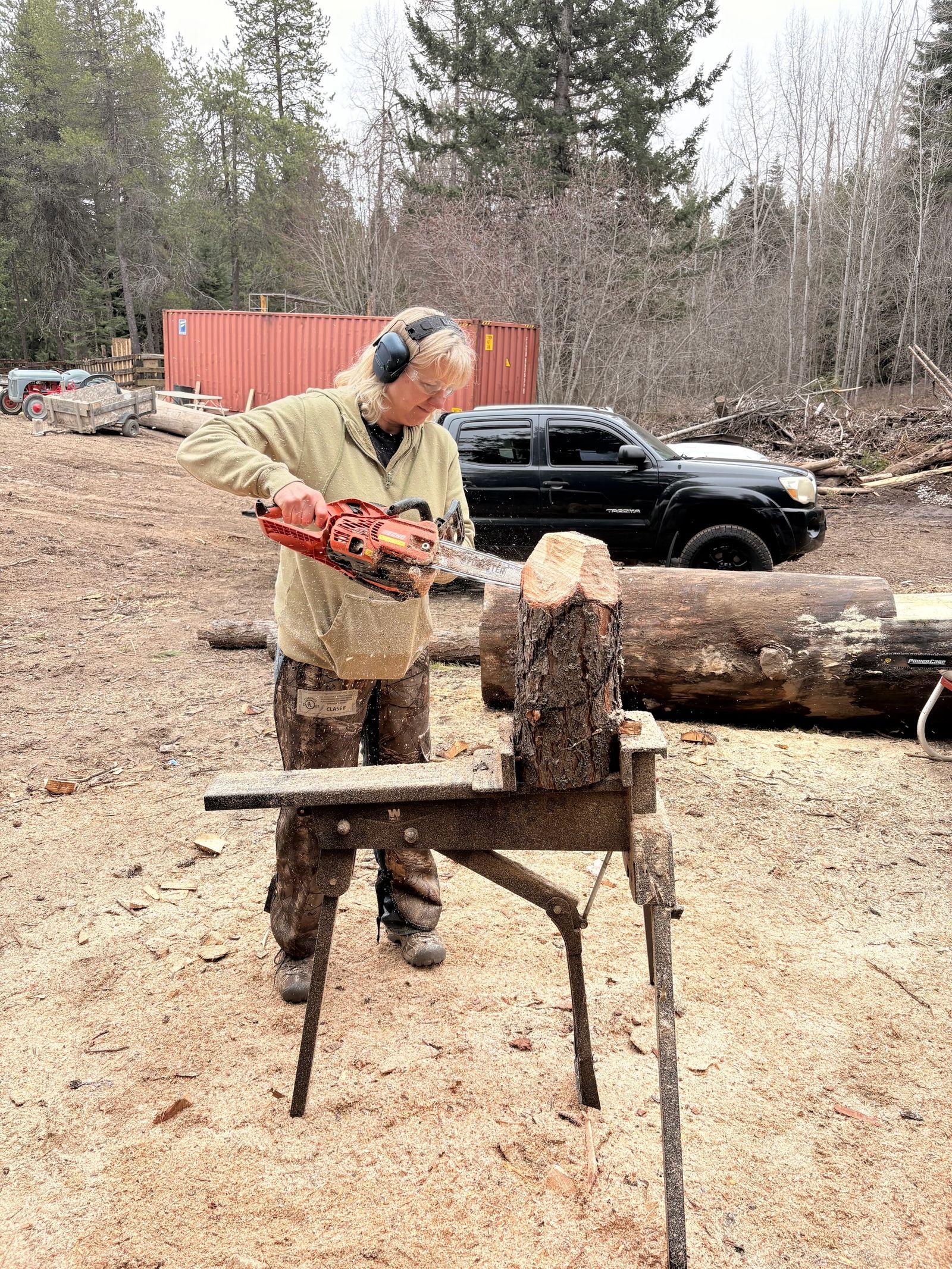 Carving retreat participant shaping a log outdoors